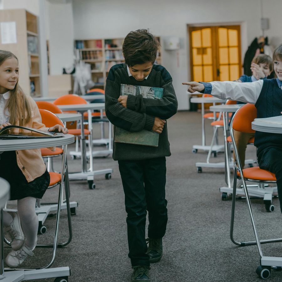 Sad kid in the school holding a book